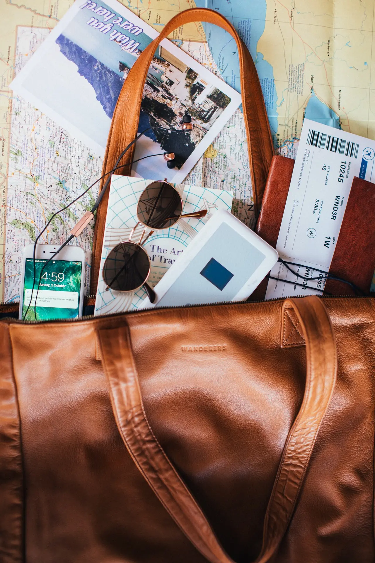 Travel items including a bag, map, and sunglasses